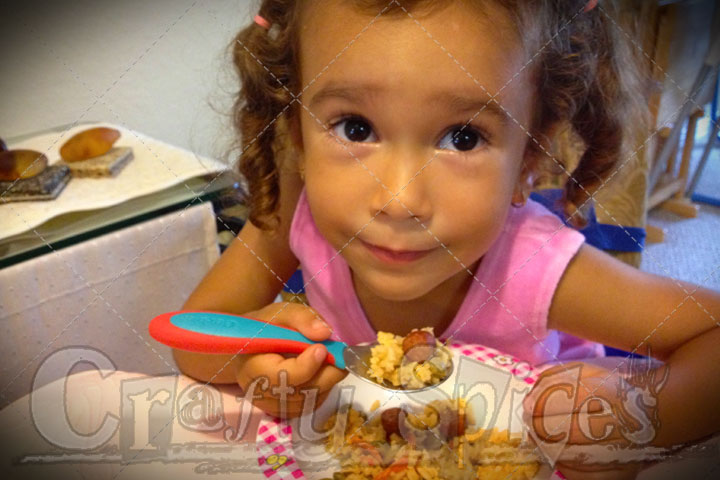 Kira enjoying Locrio de Salchichas y Gandules Verdes con Coco a great Dominican favorite