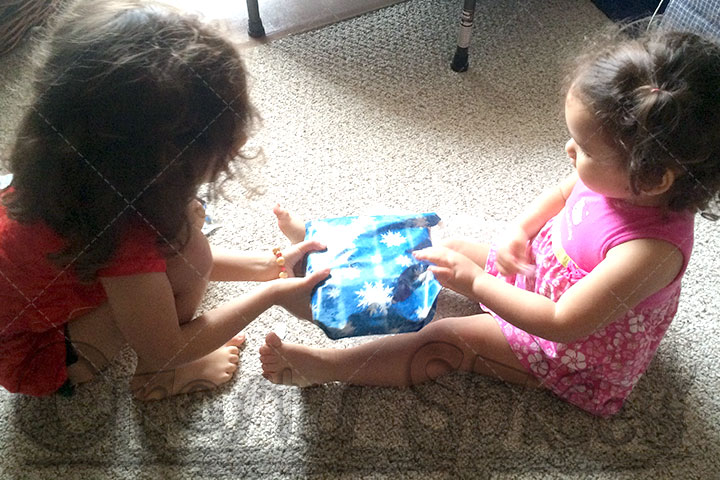 Kira handing over a gift to her baby sister